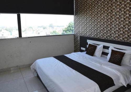 a bedroom with a large bed with a large window at Hotel Lotus Inn - Hisar in Hisār