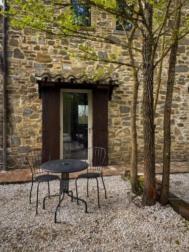 a table and chairs in front of a stone building at Agriturismo La Pomifera in Gubbio