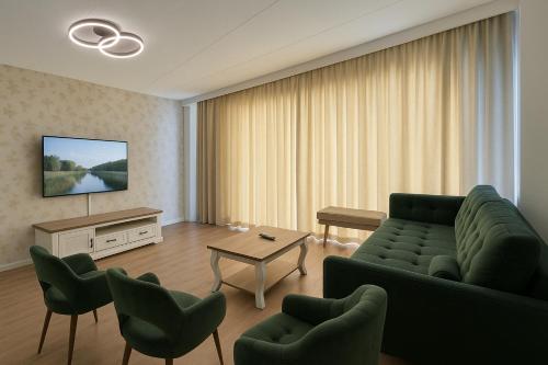 a living room with a couch and chairs and a tv at Reza Almere in Almere