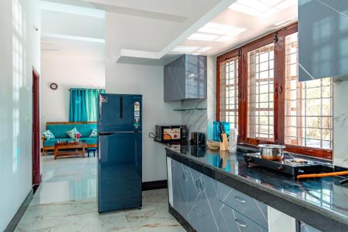 a kitchen with a blue refrigerator in a room at Aho Havens in Bengaluru