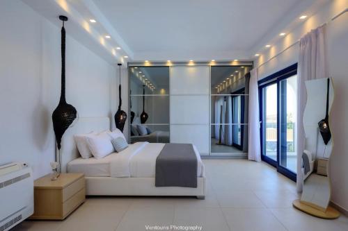 a bedroom with a bed and a television in it at Beautiful Santorini Villa 3 Bedrooms Villa Phos Private Pool & Lovely Sea View Exo Gialos in Karterados