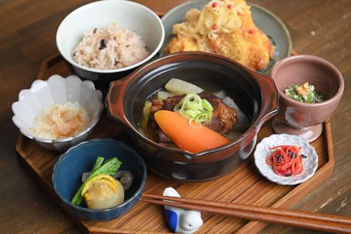 a wooden tray with various dishes of food on it at furaha in Iwamicho
