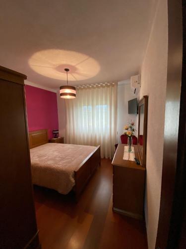 a bedroom with a large bed and a pink wall at Casa da Pizzaria in Carapito