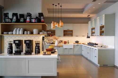 a large kitchen with white cabinets and appliances at Anastasia Hotel & Suites Mediterranean Comfort in Karistos