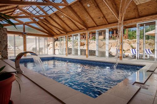 a swimming pool in a house with a large room with windows at ЕкоСадиба Пан Атаман in Skhidnitsa