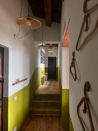 a hallway with green and white walls and stairs at Agriturismo La Pomifera in Gubbio