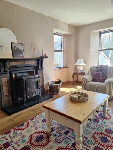 a living room with a coffee table and a fireplace at Rustic Pub Stay - 20 minutes from Killarney! in Rathmore