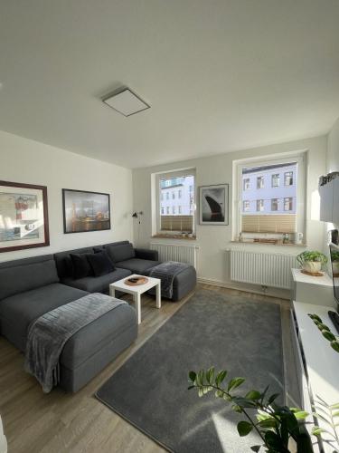 una sala de estar con un sofá y una mesa en Zentrale FeWo Küstenglück nah am Deich, en Bremerhaven