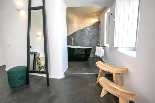 W łazience znajduje się czarna wanna i lustro. w obiekcie Luxury Santorini Villa Villa Elysian Dyo Private Hot Tub Air Conditioning 1 Bedroom Oia w mieście Foinikiá