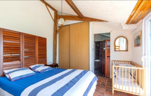 une chambre avec un lit bleu et blanc dans une pièce dans l'établissement L’Échappée du Port - Grand Jardin, à Bouin