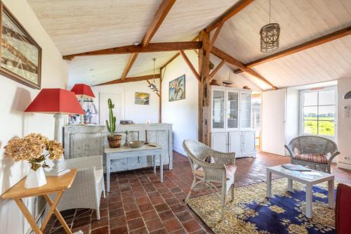 - un salon avec des plafonds en bois, une table et des chaises dans l'établissement L’Échappée du Port - Grand Jardin, à Bouin