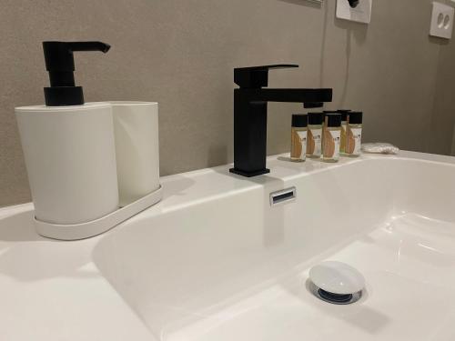 a white bathroom sink with a black faucet at B&B Platani in Avellino