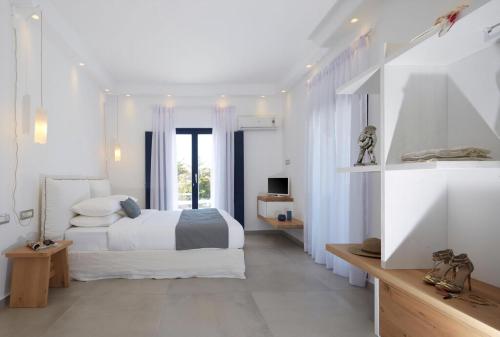 a white bedroom with a bed and a window at Lovely Santorini Villa 3 Bedrooms Villa Petra Private Pool & Outdoor Dining Area Exo Gialos in Karterados