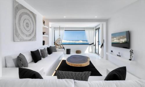 ein weißes Wohnzimmer mit einem weißen Sofa und einem Tisch in der Unterkunft Magnificent Mykonos Villa Villa Rikei 5 Bedrooms Unique Aegean Sea Views in Psarrou