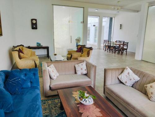 a living room with two couches and a table at Villa Idda in Padukka