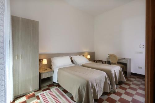a hotel room with two beds with white sheets at Villa Astoria in Taormina