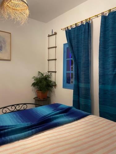 a bedroom with blue curtains and a bed at Atelier Xauen in Chefchaouene