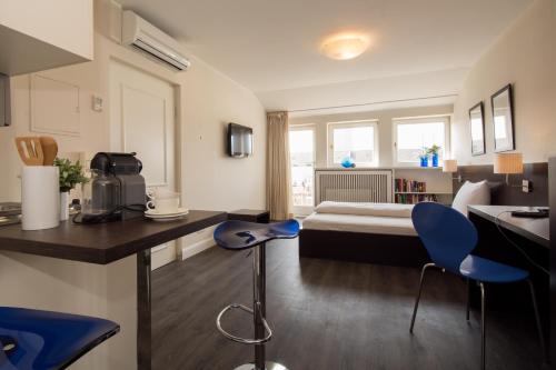 a hotel room with a bed and a desk and chairs at Living am Carlsplatz Apartment in Düsseldorf