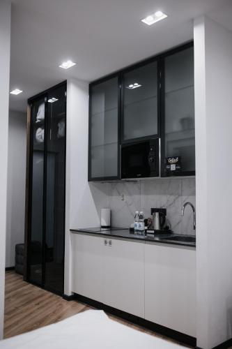 a kitchen with black and white cabinets and a sink at Mountain Residence Apartments & Chalet in Bukovel