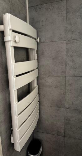 une armoire blanche dans une salle de bain à côté d'un mur dans l'établissement T2 bord de mer avec piscine, à La Garonnette-Plage