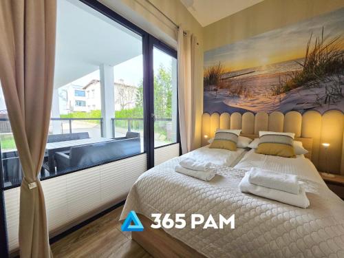 ウストロニエ・モルスキエにある365PAM - Apartament Flora Villa Solny 6-osobowy PRZY PLAŻYの大きなベッドと大きな窓のある寝室