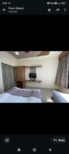 a picture of a bedroom with a bed and a tv at Dwaravati in Dwarka