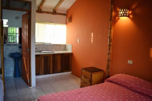 a bedroom with orange walls and a bed and a sink at Snug Bungalow - 4 people - Pool - SuperHost in Mala