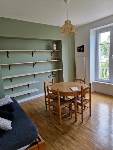 - une salle à manger avec une table, des chaises et des étagères dans l'établissement Les Dunes Résidence face à la plage des Dunes, à Fouesnant