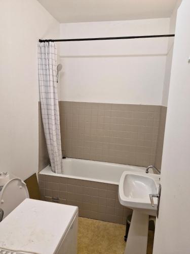 une salle de bain avec une baignoire et un lavabo dans l'établissement Les Dunes Résidence face à la plage des Dunes, à Fouesnant