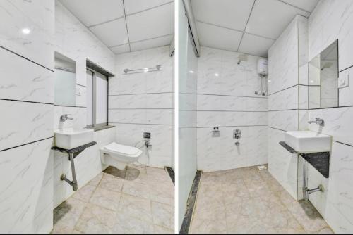 a white bathroom with two sinks and a toilet at Hotel Unicorn, Surat in Surat