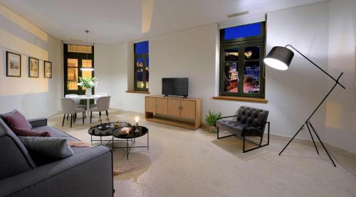 アテネにあるExquisite Athens Villa 1 Bedroom Villa Izuru Acropolis View Platia Agion Asomatonのソファとテーブルとテレビのあるリビングルーム