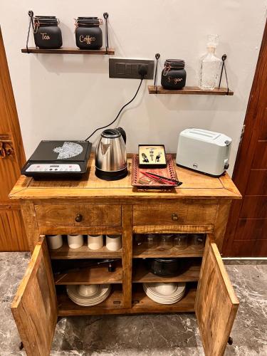 a wooden table with a microwave and a printer on it at Gita Bhawan - Elegant Escape in Haridwār