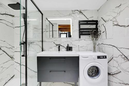 une salle de bain avec une machine à laver et un lavabo dans l'établissement Duplex Cosy Canal Saint Martin, à Paris