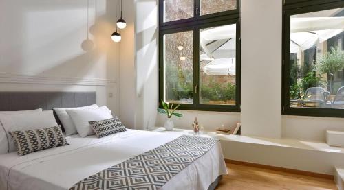 a bedroom with a white bed and two windows at Magnificent Athens Villa 1 Bedroom Villa Aizen Garden View Ground Floor Platia Agion Asomaton in Athens