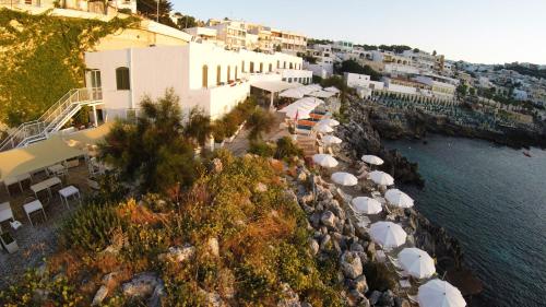 an aerial view of a resort with umbrellas and the water at Hotel La Roccia in Castro di Lecce