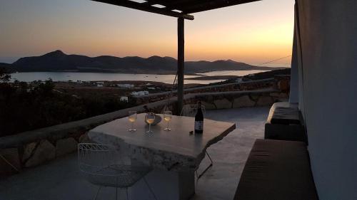 a table with wine glasses and a bottle of wine at Cute Antiparos Villa 1 Bedroom Villa Sunset Amazing Sea Views in Andiparos