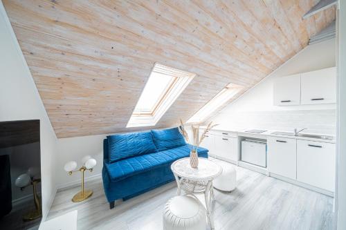 a living room with a blue couch and a table at Apartament 01, Rodzinny z Tarasem, Grzybowo Centrum - Nadmorska 26 in Grzybowo