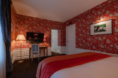 a bedroom with red walls and a bed and a desk at Hôtel De Buci in Paris