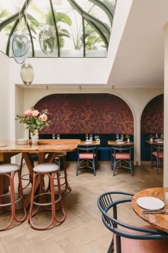 a dining room with tables and chairs and a skylight at Hôtel De Buci in Paris