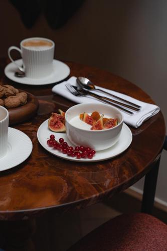 a table with a bowl of fruit and a cup of coffee at Hôtel De Buci in Paris