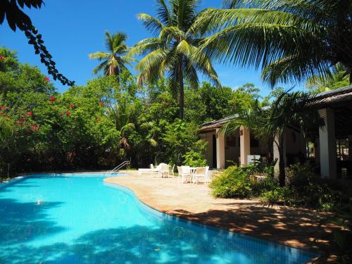 basen obok domu z palmami w obiekcie Villa Tropical PdF Completo com Cozinheira excelente incluida w mieście Mata de São João