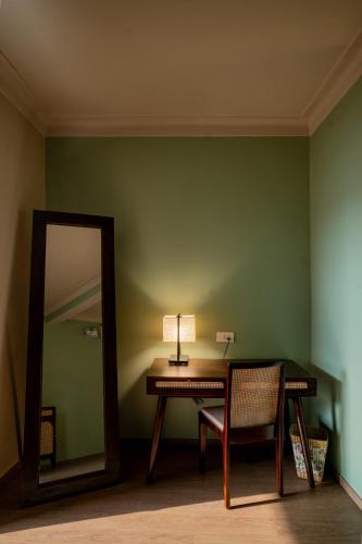 a desk with a lamp and a mirror in a room at Kssemya in Mandrem