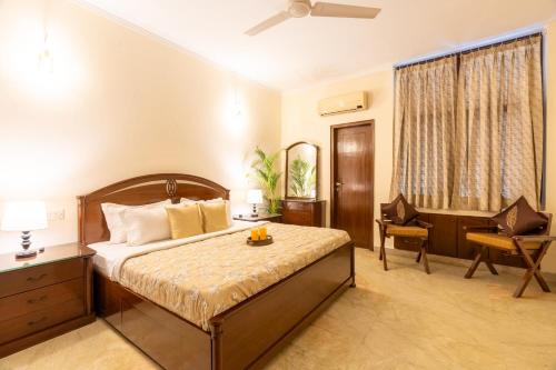 a bedroom with a bed and a desk and a chair at Homlee-LushGreen 2BHK-South DEL-Ground Floor in New Delhi