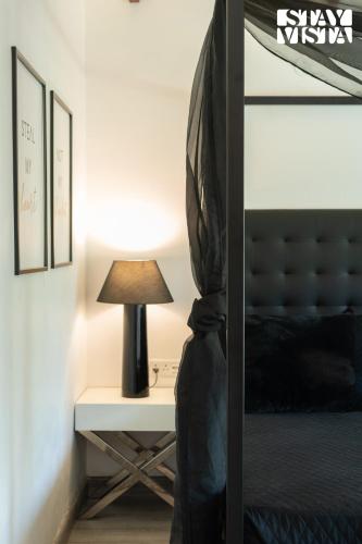 a bedroom with a bed and a table with a lamp at StayVista at La Casa Oberoi with Lawn & Mountain View in Bhīm Tāl