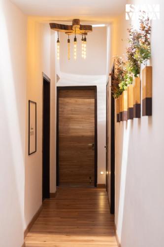 a hallway with a wooden door and a chandelier at StayVista at La Casa Oberoi with Lawn & Mountain View in Bhīm Tāl