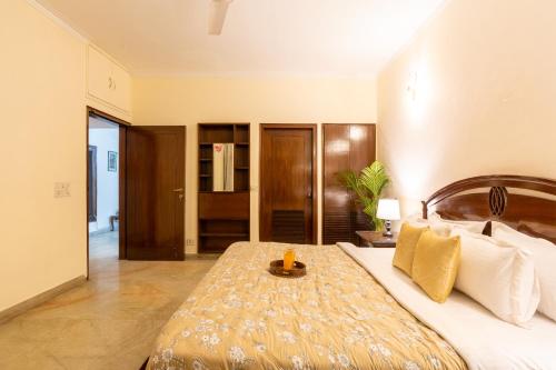 a bedroom with a large bed with a wooden headboard at Homlee-LushGreen 2BHK-South DEL-Ground Floor in New Delhi