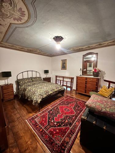 a bedroom with a bed and a mirror and a rug at Rifugio Rustico con Vista sulle Colline Toscane in Settignano