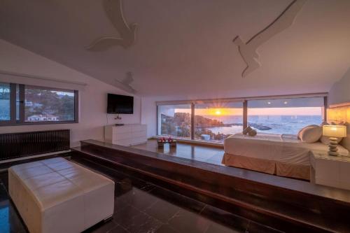 a bedroom with a bed and a view of the ocean at Ikaria Beachfront Villa 7 Bedrooms Villa Indigo Blue Haven Infinity Pool With Stunning Aegian Sea Views Gialiskari in Gialiskari
