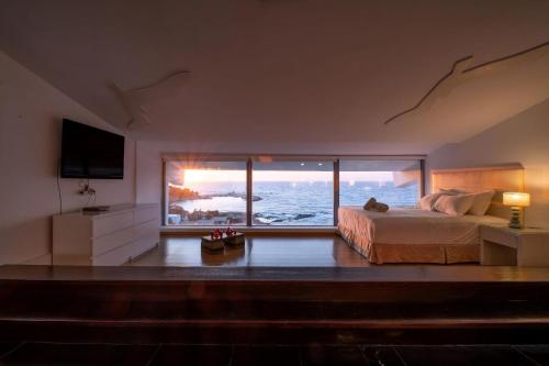 a bedroom with a bed and a view of the ocean at Ikaria Beachfront Villa 7 Bedrooms Villa Indigo Blue Haven Infinity Pool With Stunning Aegian Sea Views Gialiskari in Gialiskari