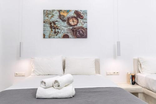 a white bedroom with a bed with towels on it at Superb Naxos Apartment Grand Suite In The Heart Of Town Balcony City Views Saint George in Naxos Chora